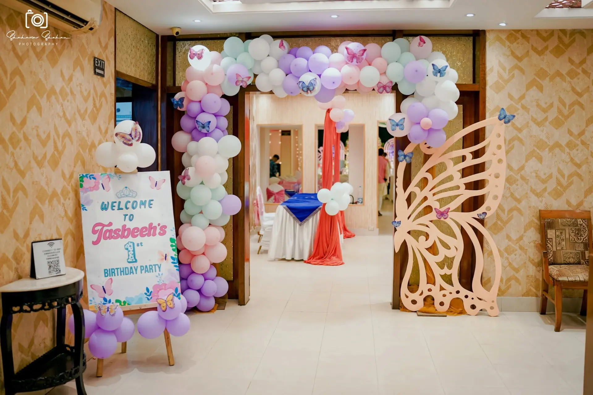 Balloon arch entrance with welcome board and butterfly cutout