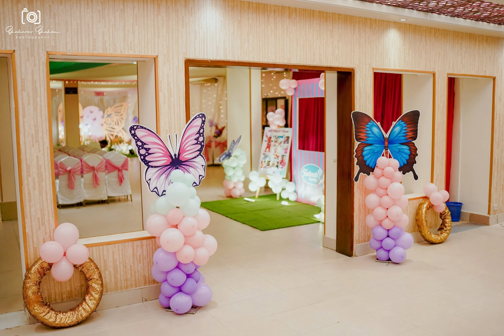 Pastel balloon columns with butterfly cutouts along the hallway