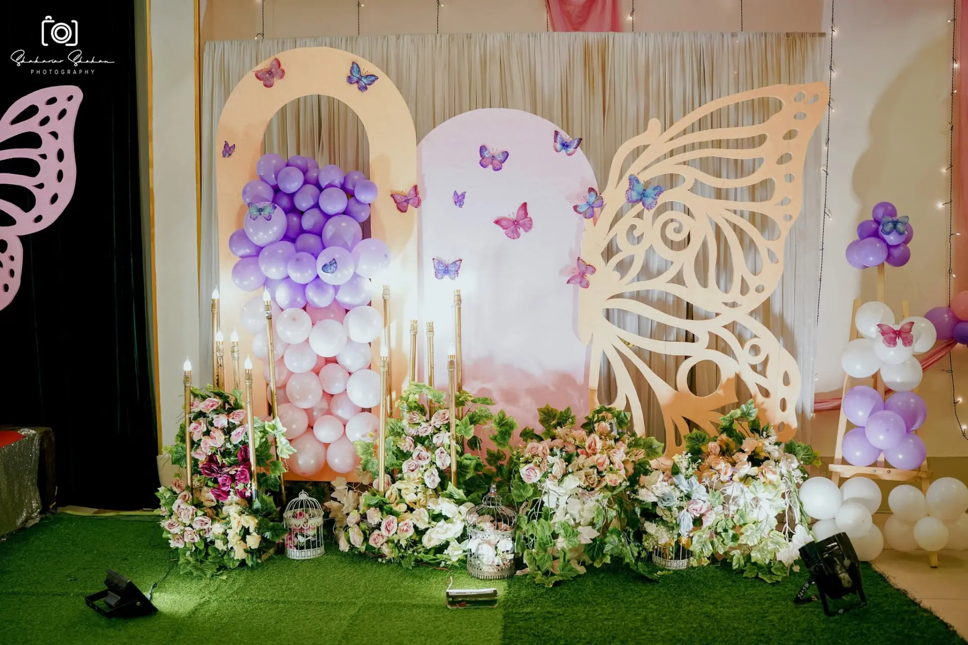 Pastel arch photo backdrop with balloons, florals and butterfly wing