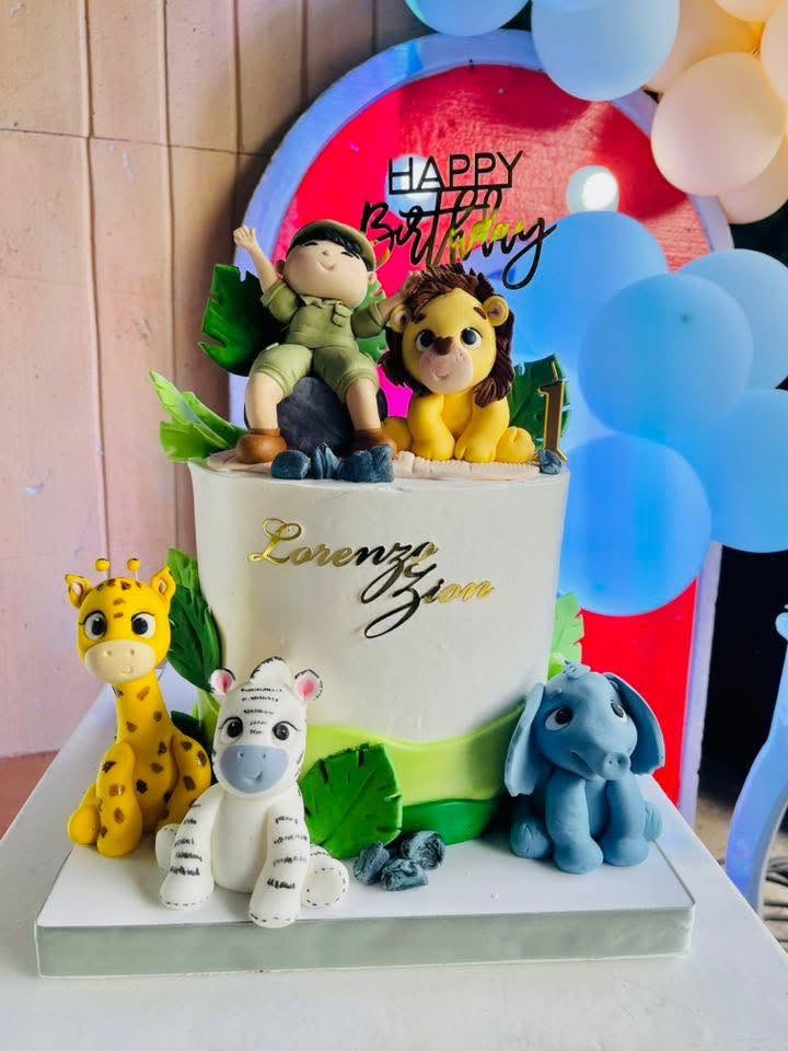 Safari themed first birthday cake with animal figurines