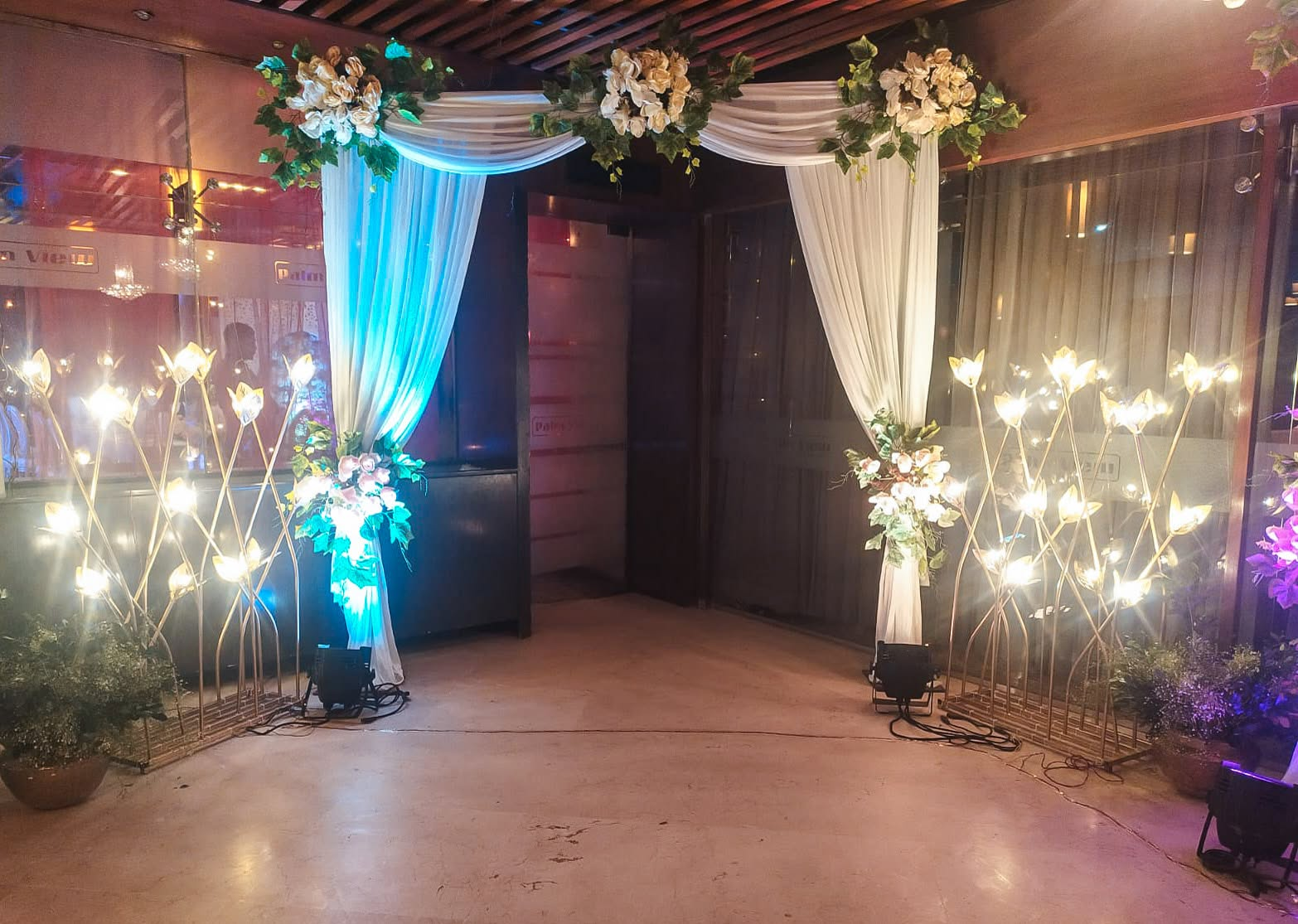 Draped entrance with floral swags and tulip lamps