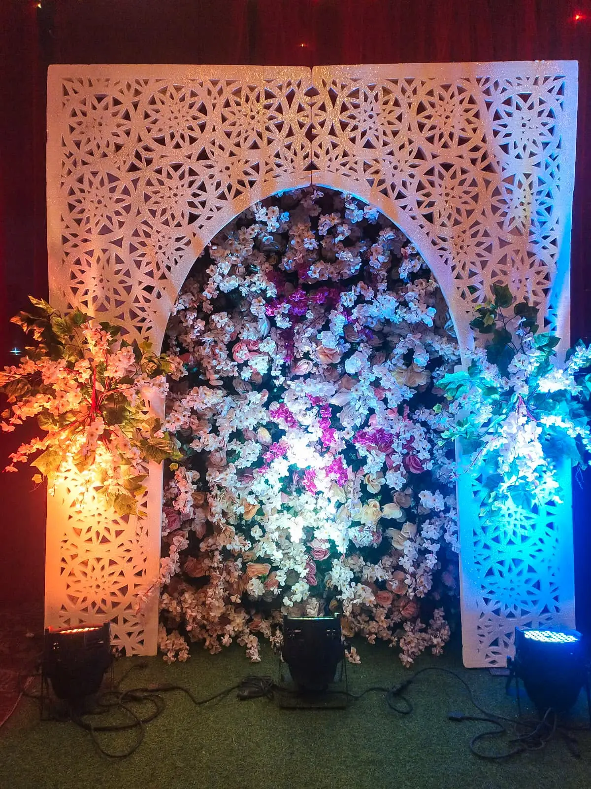 Floral filled arch photo backdrop with accent lighting