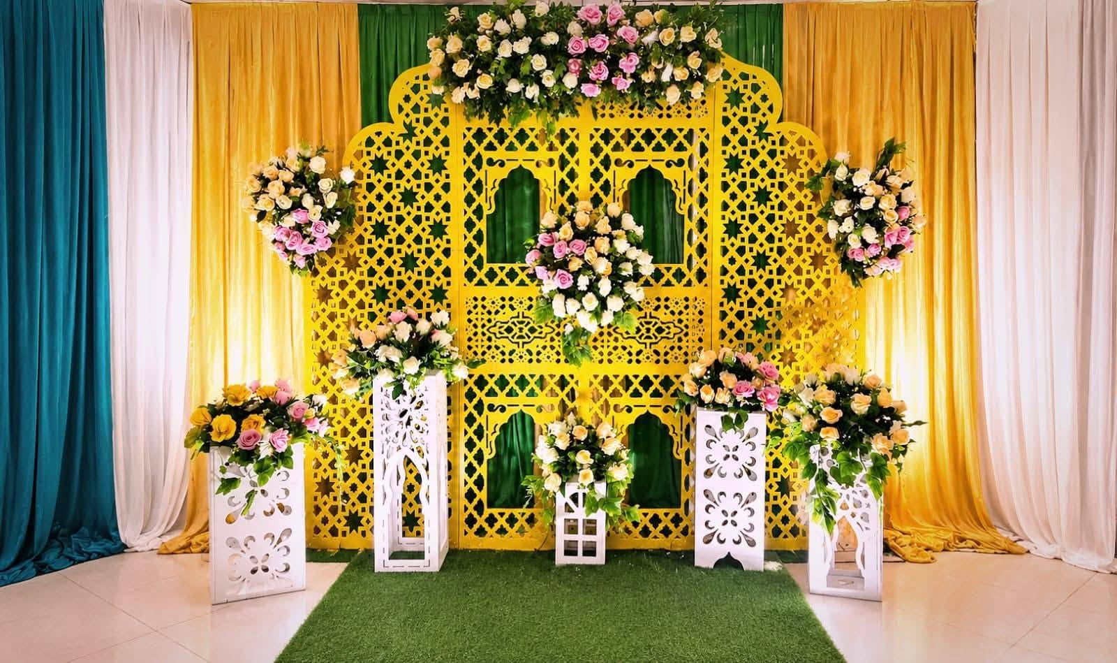 Yellow lattice haldi backdrop with rose bouquets