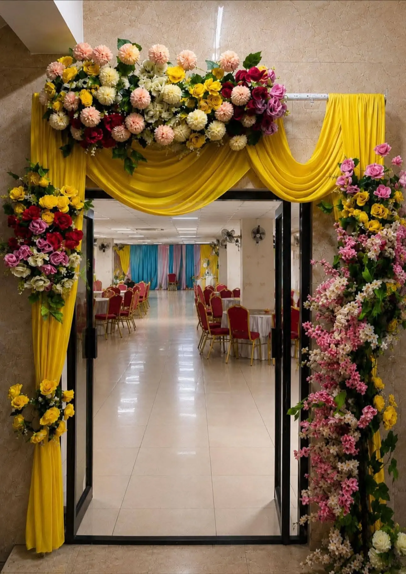 Floral entrance arch with yellow drapes