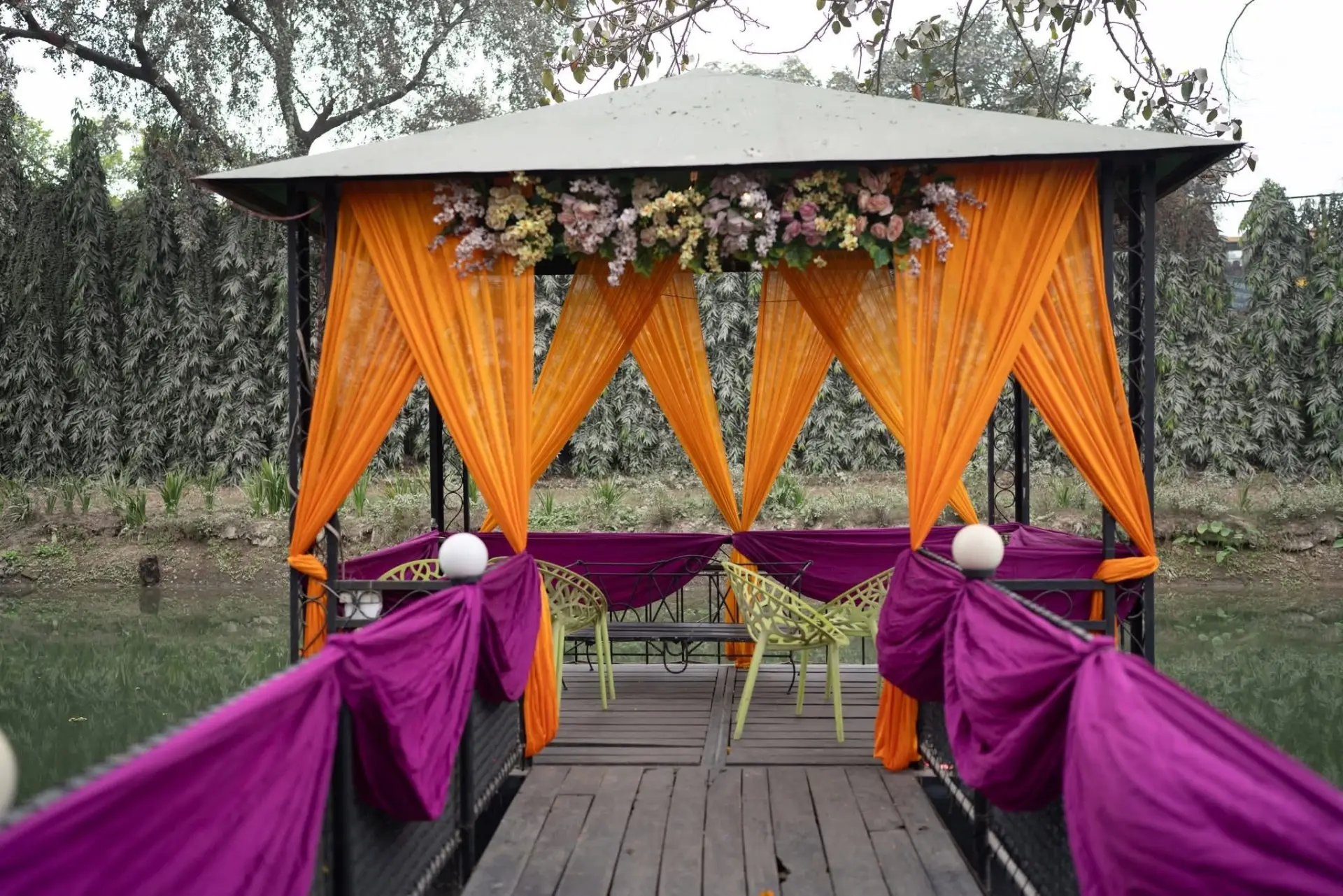Lakeside gazebo draped in orange and purple fabric