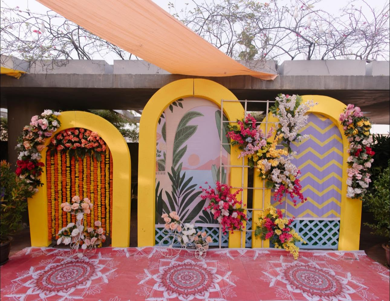 Yellow arched photo booth panels with marigold and fresh flowers