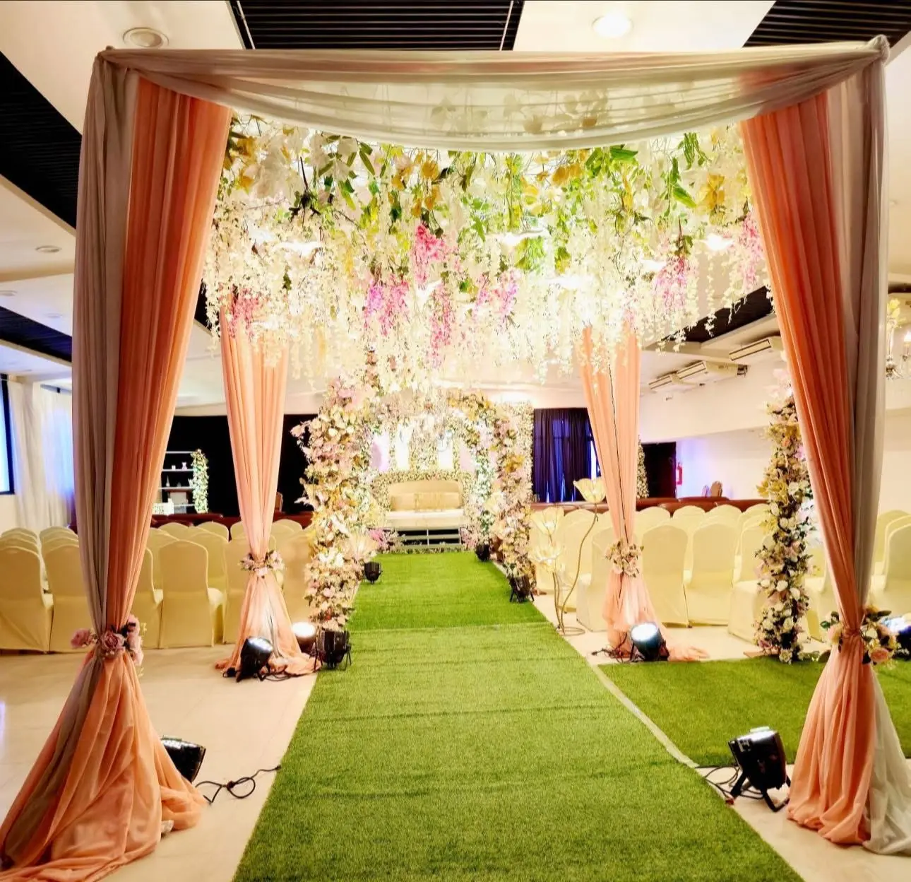 Draped entrance canopy with hanging florals over the aisle