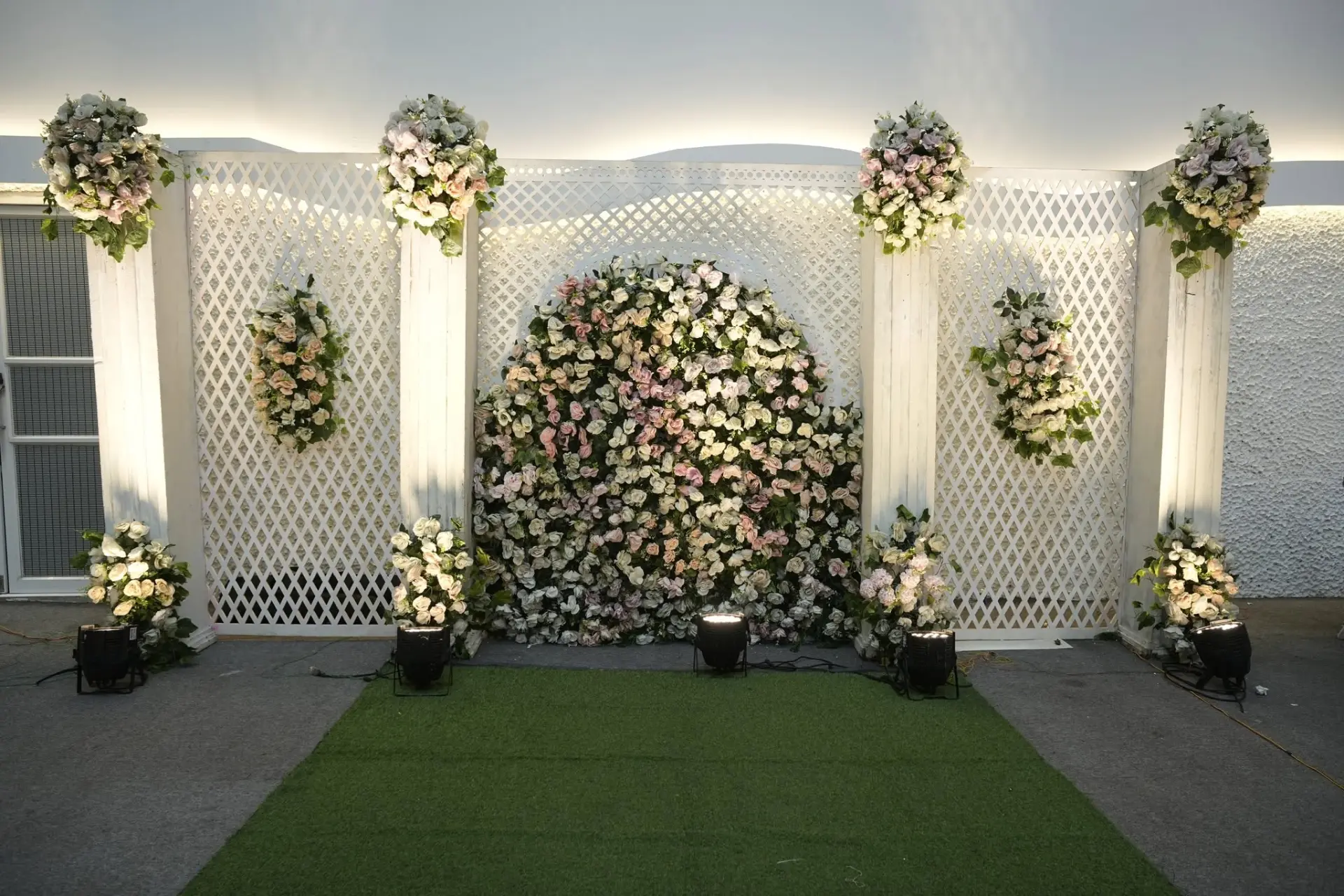 White lattice photo backdrop with blush floral dome