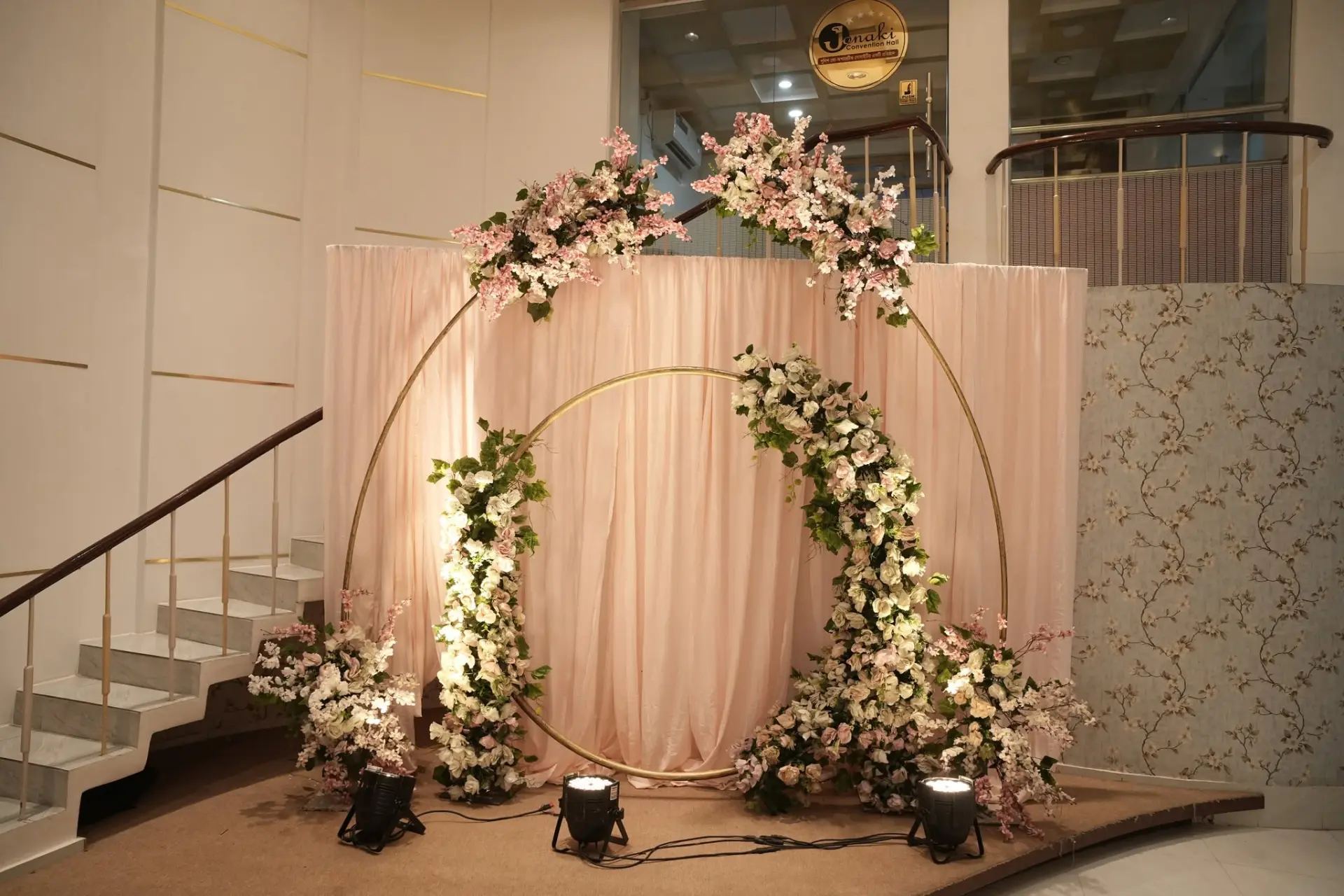 Gold circular floral ring backdrop with blush drapes