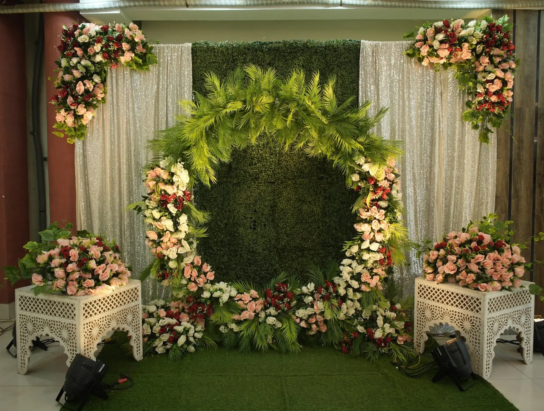 Circular palm and rose photo backdrop with sequin drapes