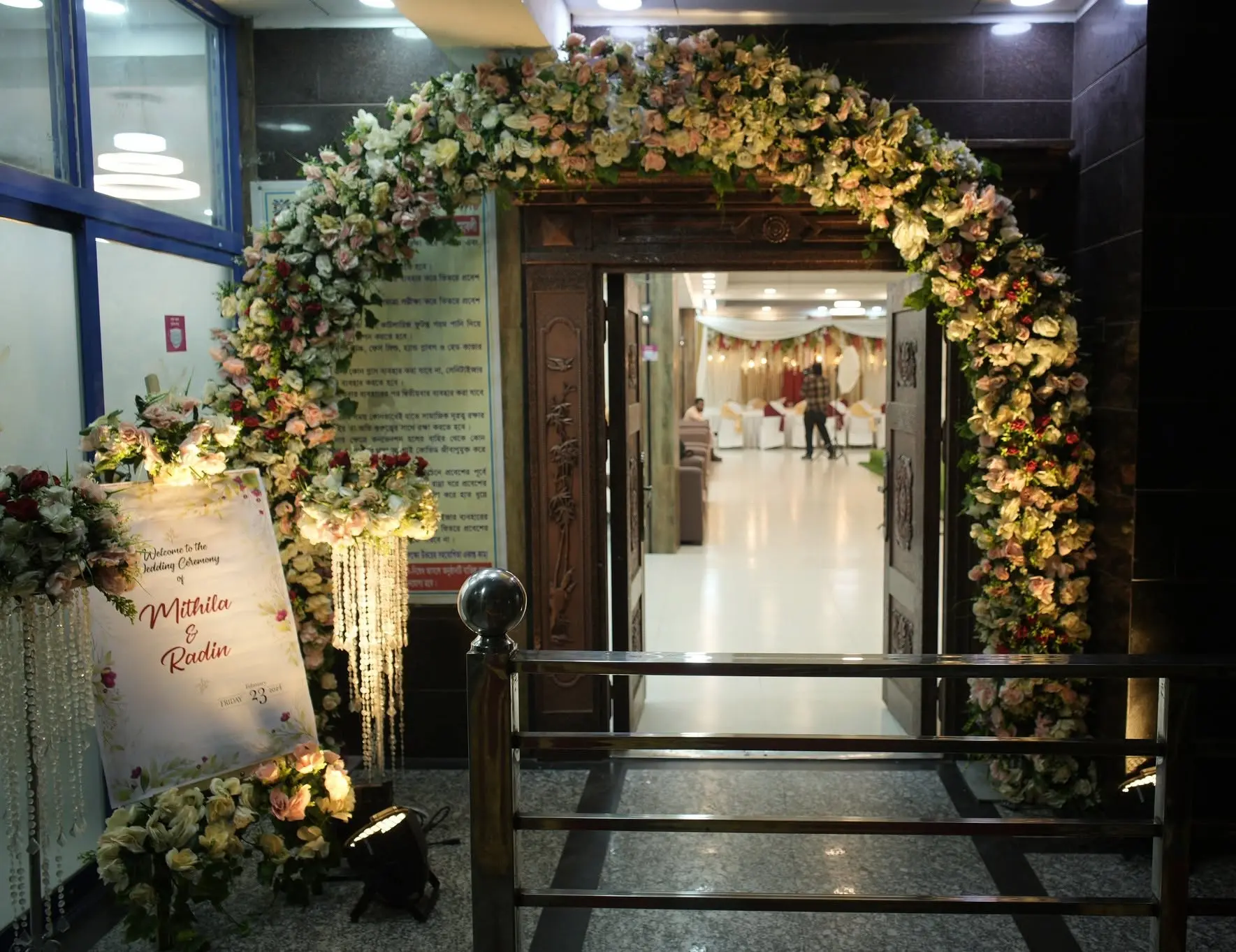 Floral entrance arch with welcome sign at the hall doorway